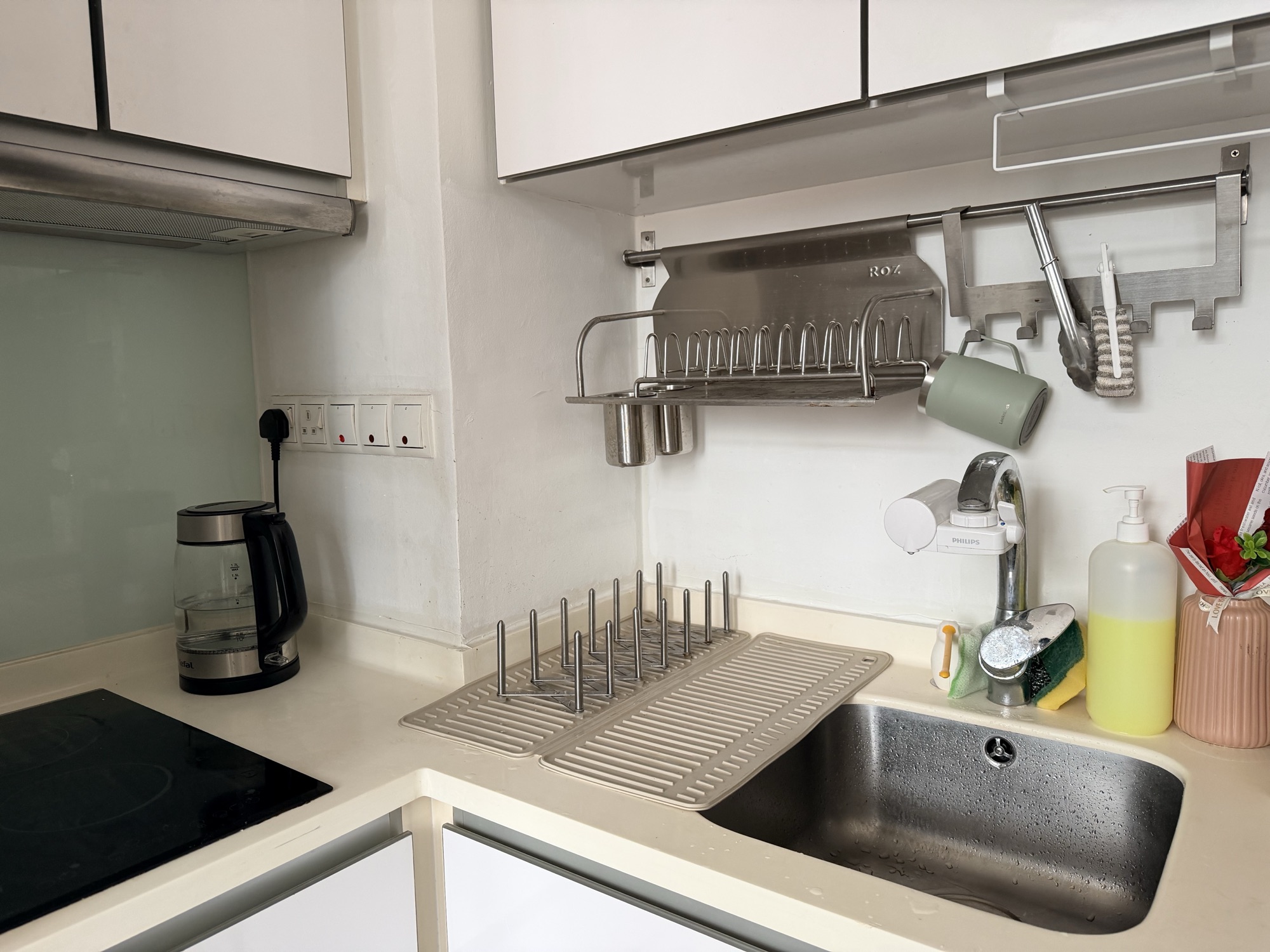 The kitchen: induction hob, extractor, stainless sink with filter tap and glossy white cabinetry