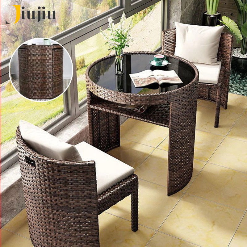 Brown rattan balcony set: round glass-top table with two tub chairs and cushions