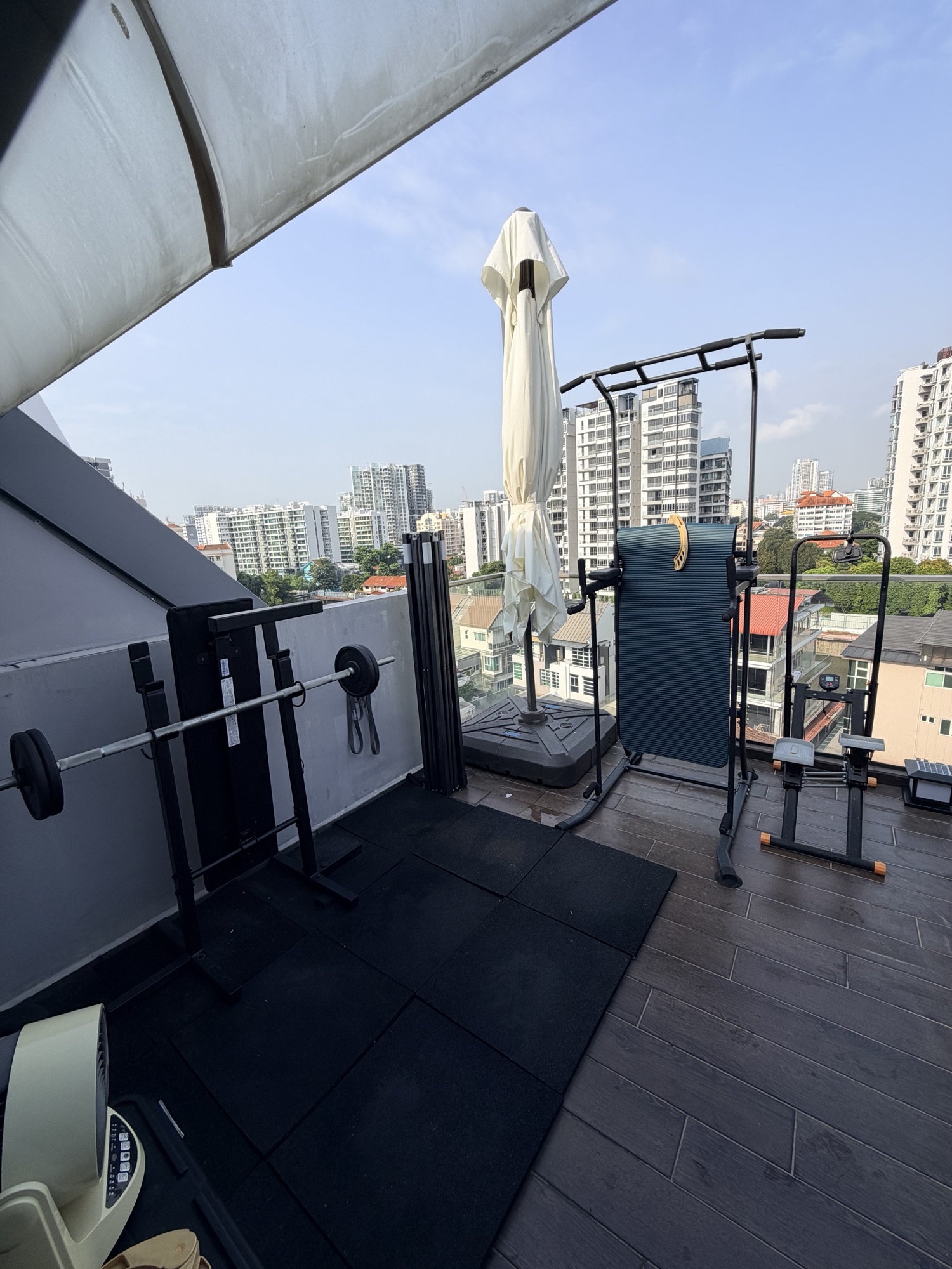 The rooftop terrace at morning, with gym equipment and the cantilever umbrella
