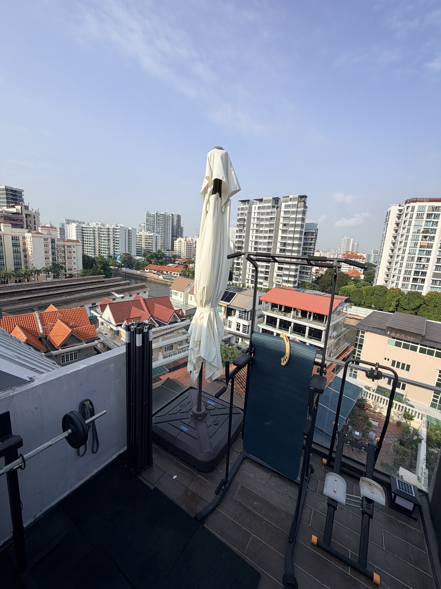 Looking out over the glass balustrade: rooftops, a canal and greenery below the penthouse