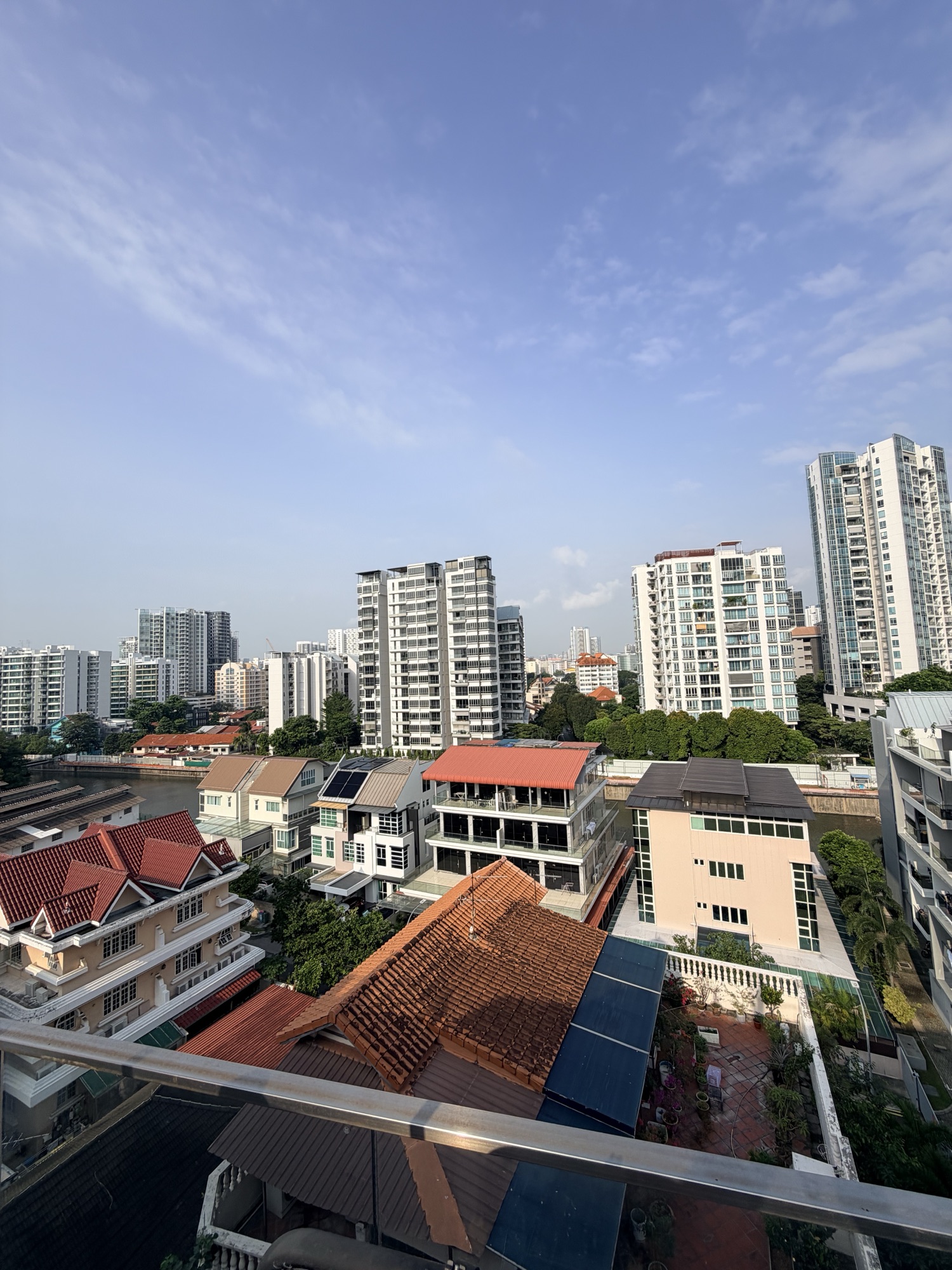 The morning view from the penthouse: terracotta rooftops, a canal and the city skyline under a wide sky